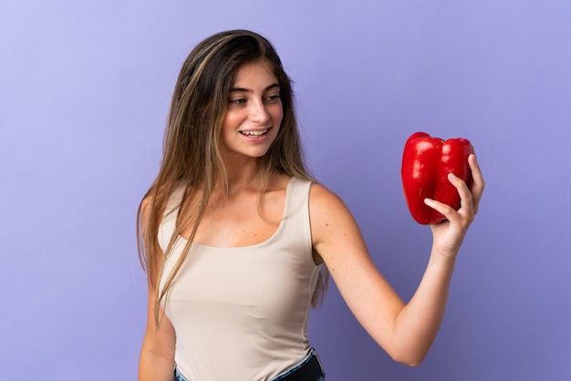 Giovane donna che tiene un peperone rosso