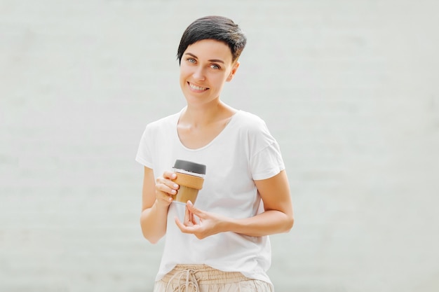 Young woman  holding reusable coffee mug.  Sustainable lifestyle. Eco friendly concept.