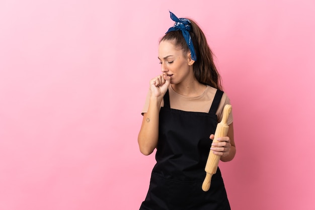 Young woman holding a rolling pin coughing a lot