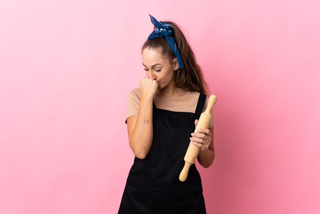 Photo young woman holding a rolling pin having doubts
