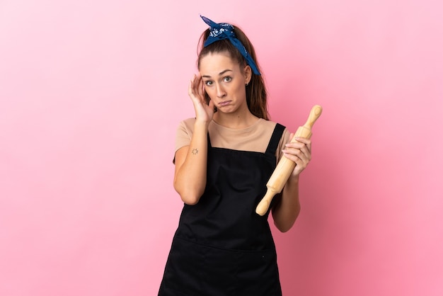 Young woman holding a rolling pin thinking an idea