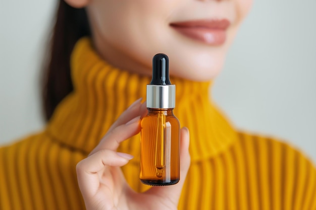 Young woman holding serum bottle with dropper Beauty cosmetics and skincare concept Natural essential oil or favorite cosmetic product in glass bottle with pipette everyday skin care routine