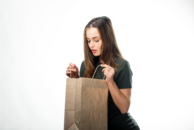 白い背景のショッピングバッグを持った若い女性