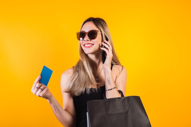 Photo young woman holding shopping bags and talking on the phone.