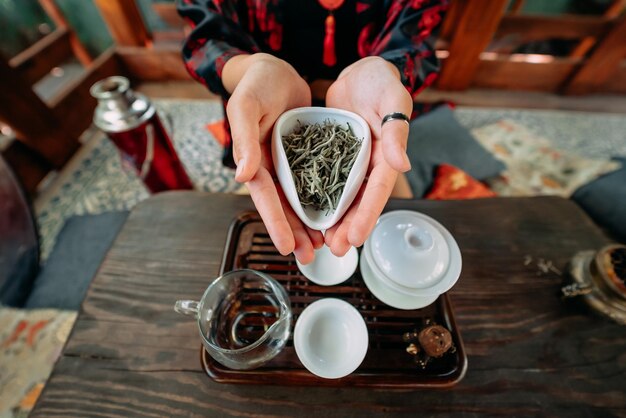 Young woman holding a small bowl of green herbal tea