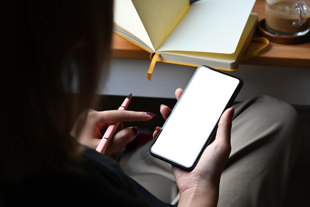 Young woman holding smart phone with white blank display for graphic display montage