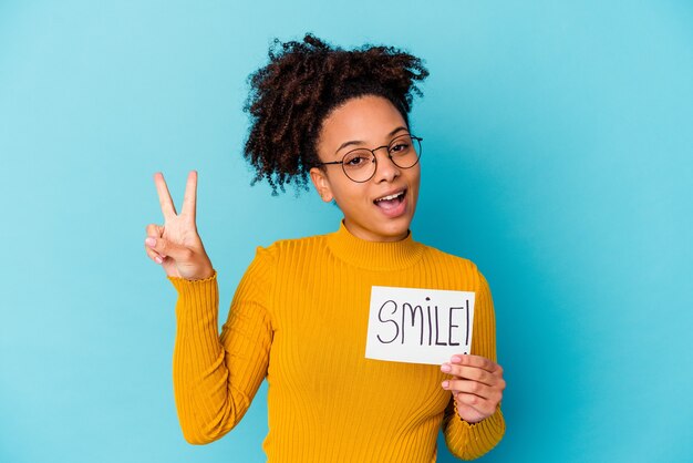 Young woman holding a smile concept joyful and carefree showing a peace symbol with fingers