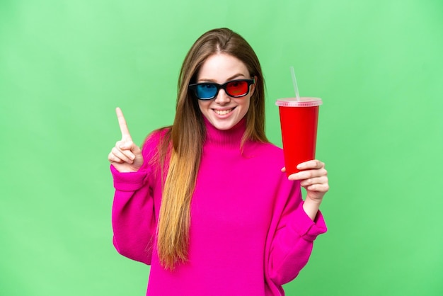 Young woman holding soda while watching a 3D movie pointing up a great idea