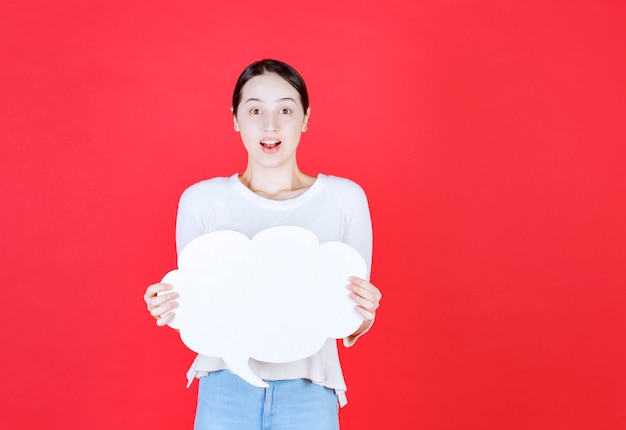 \young woman holding speech bubble with a cloud shape