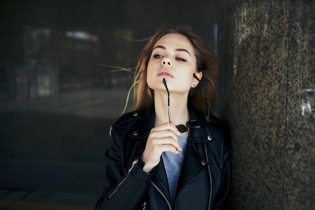 Photo young woman holding sunglasses while looking away