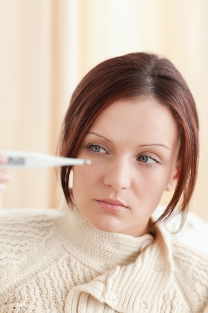 Photo young woman holding a thermometer