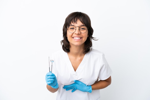 Young woman holding tools isolated on white background smiling a lot