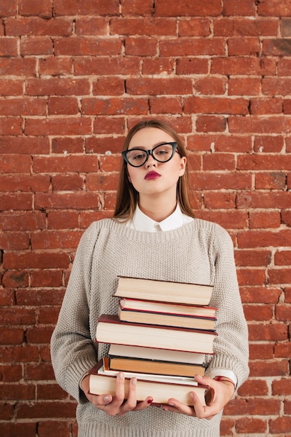 Young woman holding tower of books