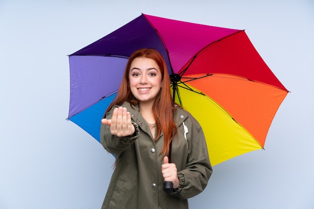 孤立した壁に傘を保持している若い女性