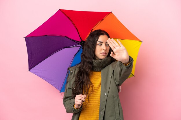 Young woman holding an umbrella isolated