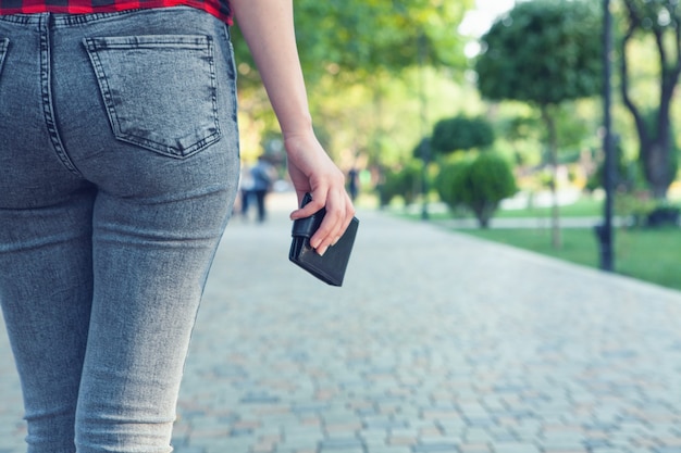 Foto giovane donna che tiene il portafoglio nel parco