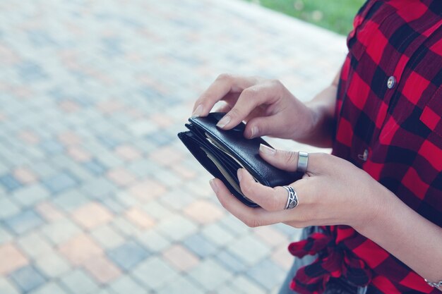 Young woman holding wallet in the park