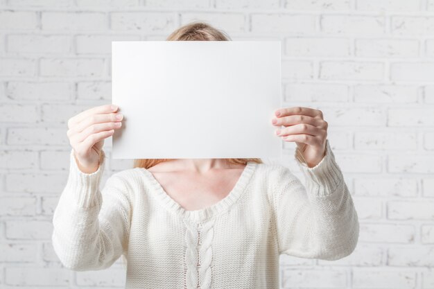 Photo young woman holding white banner with a place for your info