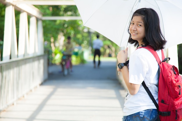 Photo young woman holding a white umbrella.