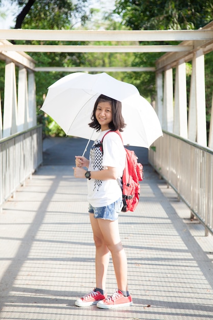 Young woman holding a white umbrella.