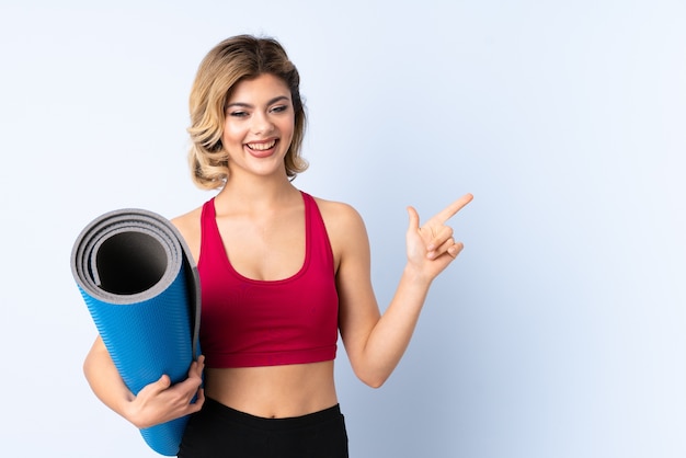 Young woman holding a yoga mat