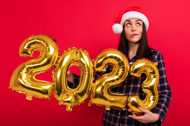 若い女性が2023年の新年の形をした風船を持っている 来たる新年