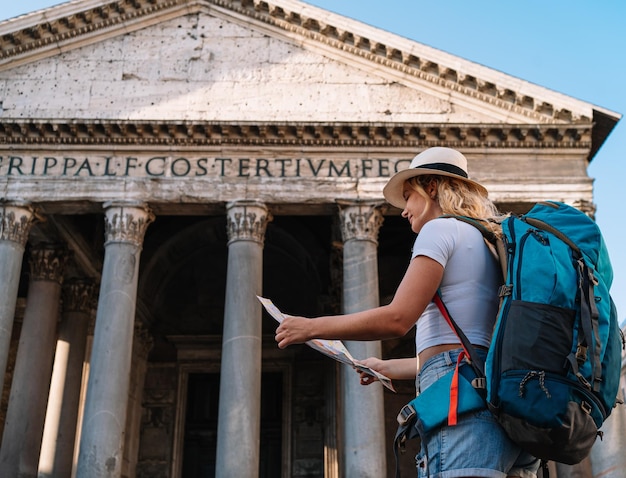 Young woman holds her map of Rome to discover the city and get to know it better digital nomad