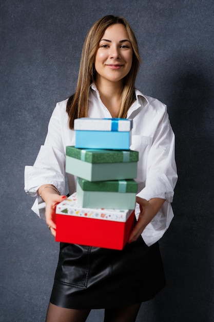 A young woman holds out boxes of gifts to the camera Christmas holidays winter holiday