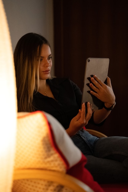 young woman at home calm on the sofa looking at the tablet