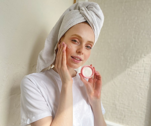 Young woman at home with a towel on her head