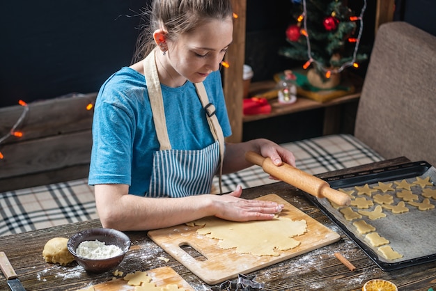 Young woman housewife makes dough for cooking festive gingerbread