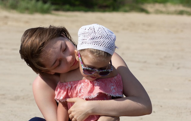 Young woman hugging a child with love and tenderness