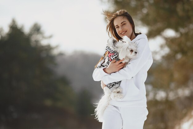Молодая женщина обнимает свою собаку на открытом воздухе