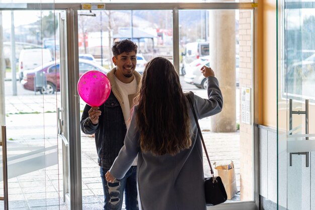 Young woman hugging her Latin boyfriend thanking him for the Valentines Day surprise