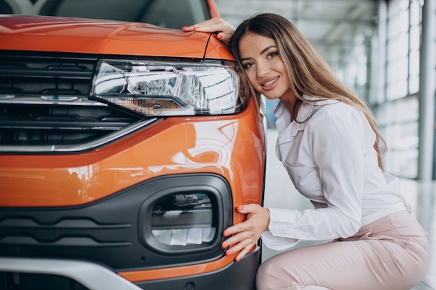 Foto giovane donna che abbraccia la sua nuova auto