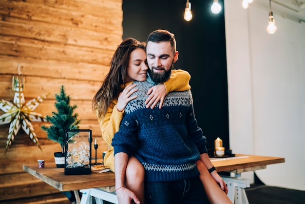 Young woman hugging young man from behind playfully