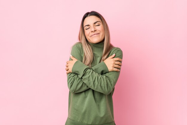 Young woman hugs, smiling carefree and happy