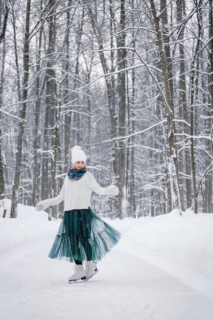 A young woman ice skating alone in park or forest on snowy\
winter day winter activities