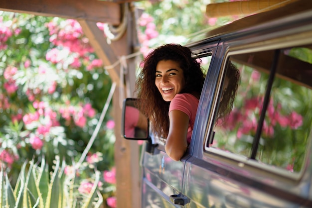 写真 ピンクの花と美しいキャンプでキャンピングカーの若い女性