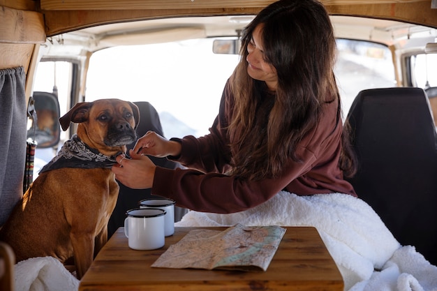 写真 彼女の犬の首にバンダナを結ぶキャンピングカーの若い女性