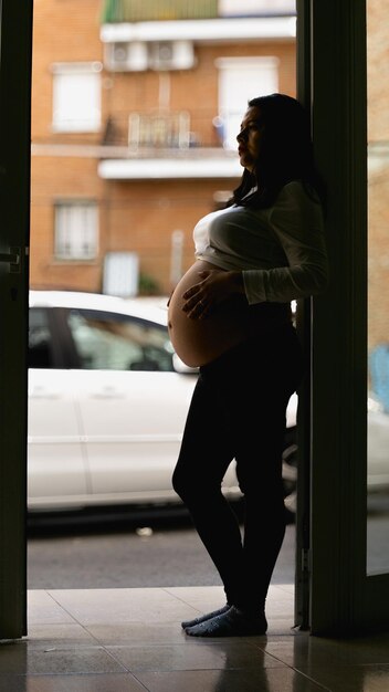 写真 家の入り口で横たわっている若い女性