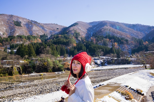 Фото Молодая женщина в красной шапочке с красивым пейзажем, расположенная в японии
