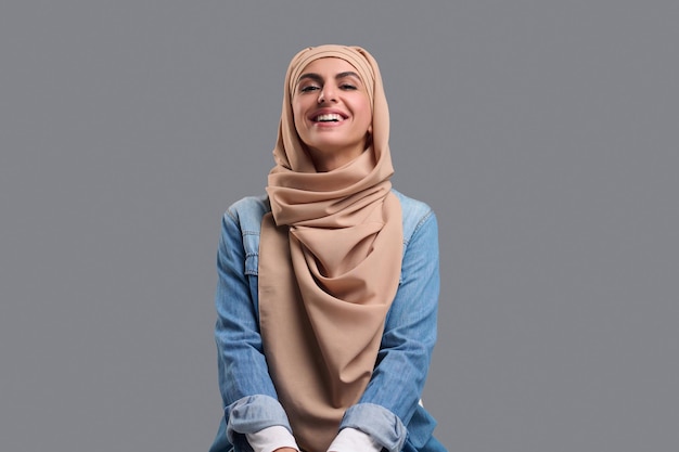 사진 귀엽고 웃고 있는 베이지색 히잡을 쓴 젊은 여성