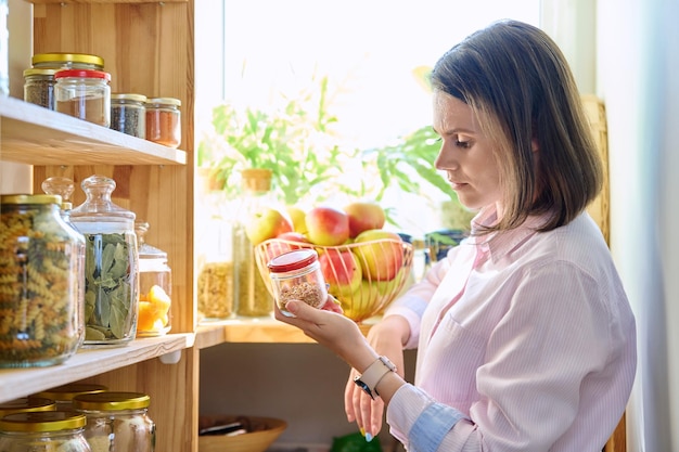 사진 식료품 용기 를 들고 있는 주방 에 있는 젊은 여자