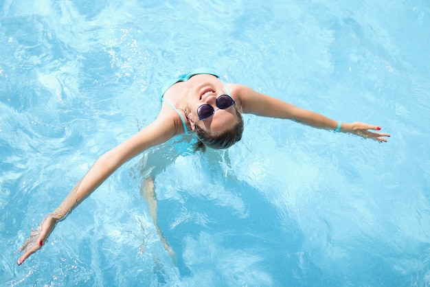 수영장 평면도에서 수영하는 선글라스에 젊은 여자