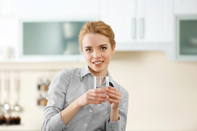 Фото Молодая женщина на кухне питьевой воды