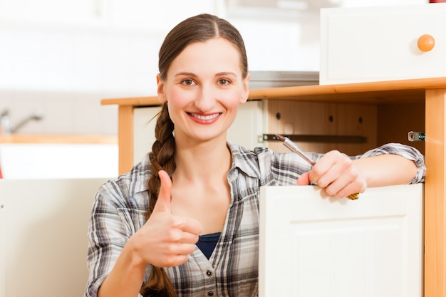 Young woman is assembling a cupboard