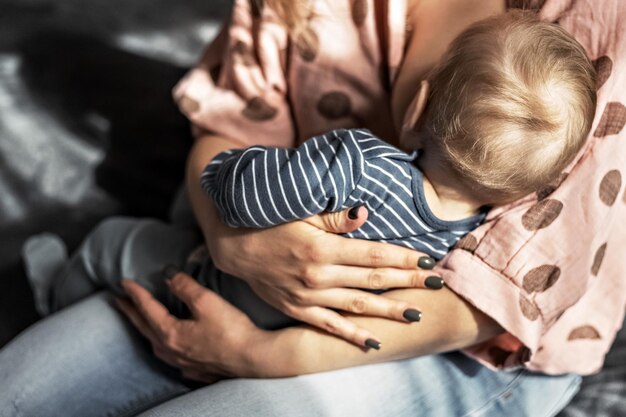 A young woman is breastfeeding her little son breastfeeding motherhood family