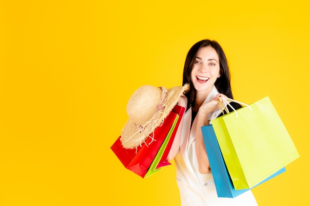 Photo a young woman is carrying colorful shopping bags.