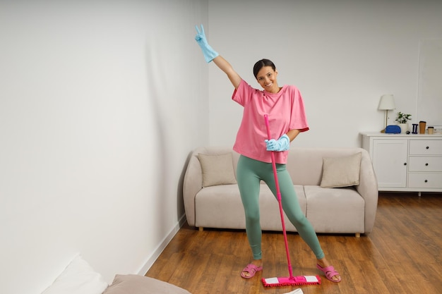 A young woman is cleaning mop living room